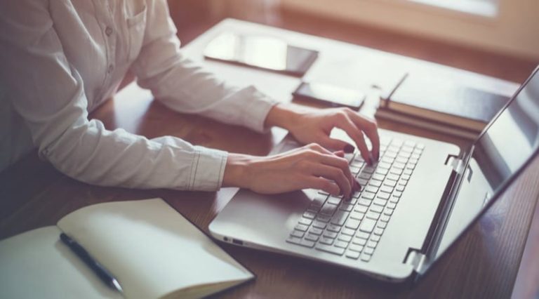 Businesswoman typing on laptop at workplace