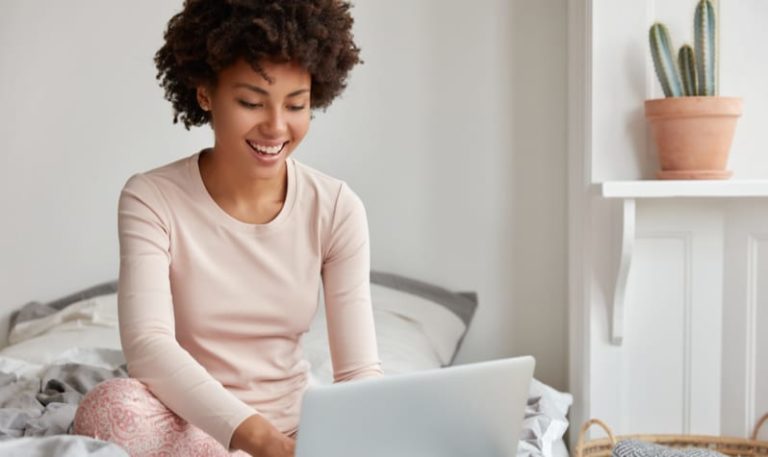 woman-in-pjs-on-laptop-in-bed