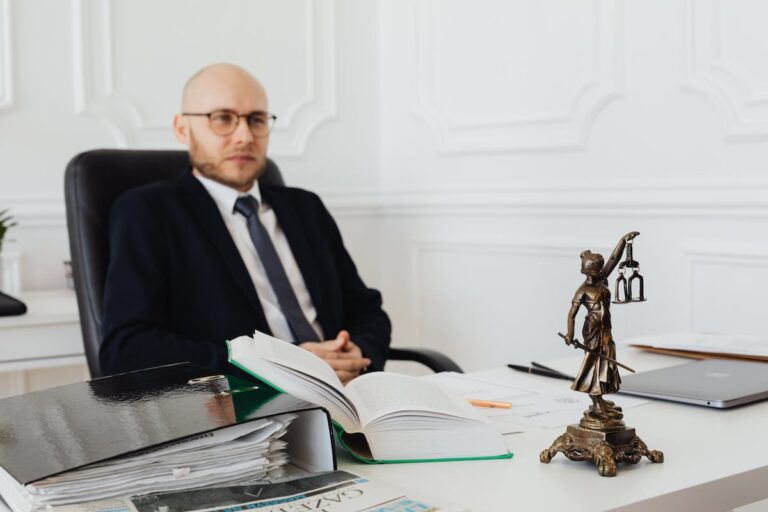 Bald Man Sitting Wearing Eyeglasses and Black Suit