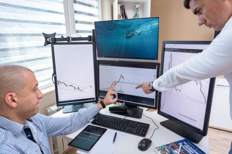 Men Analyzing the Line Graph on the Monitor of a Computer