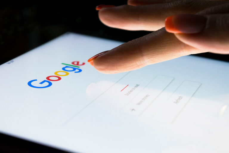 Sankt-Petersburg, Russia, November 8, 2017: A woman's hand is touching screen on tablet computer iPad Pro at night for searching on Google search engine. Google is the most popular Internet search engine in the world.