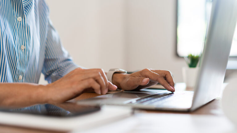 Close up hands of businesswoman typing on laptop keyboard to working and searching business data.